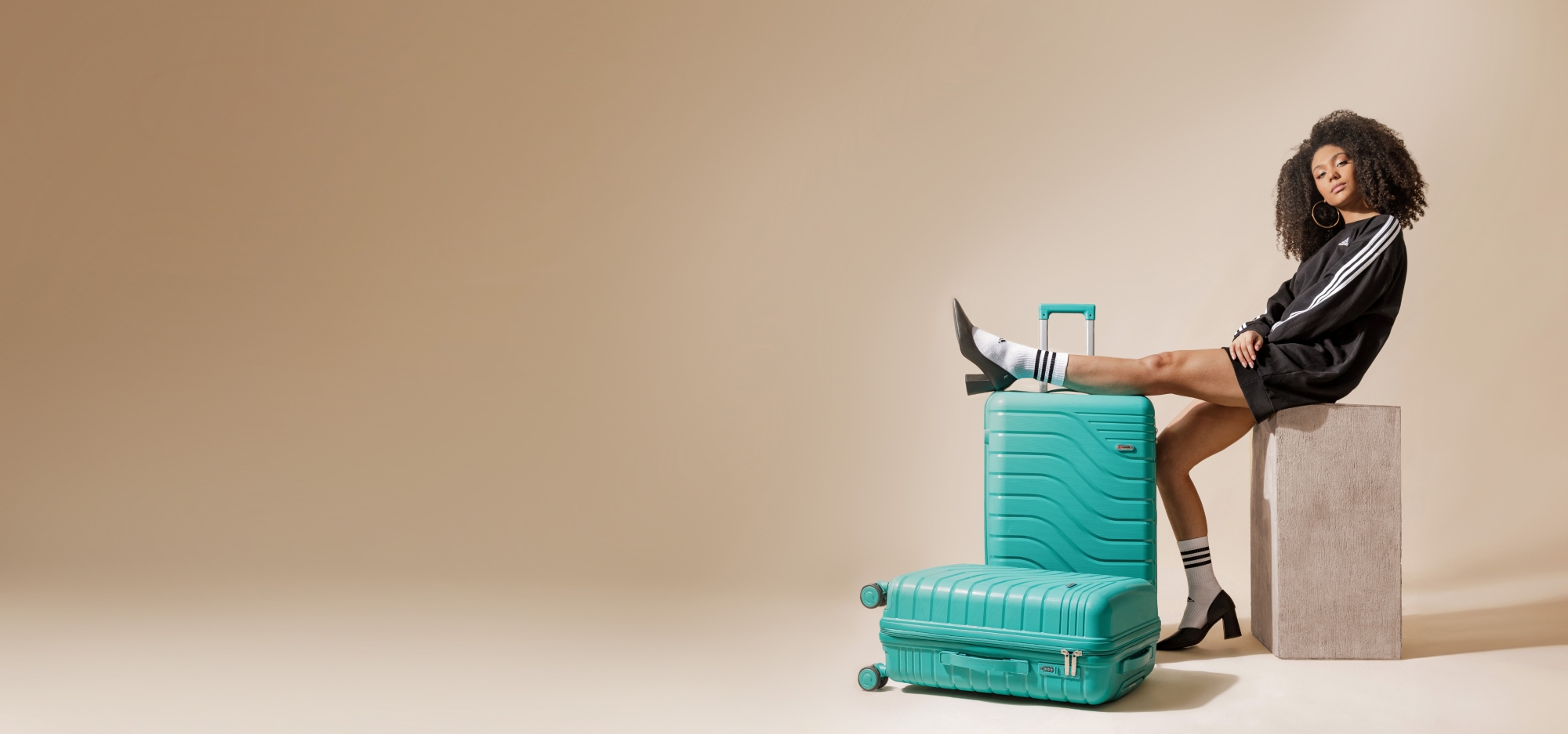 Mulher sentada sobre malas Tonin